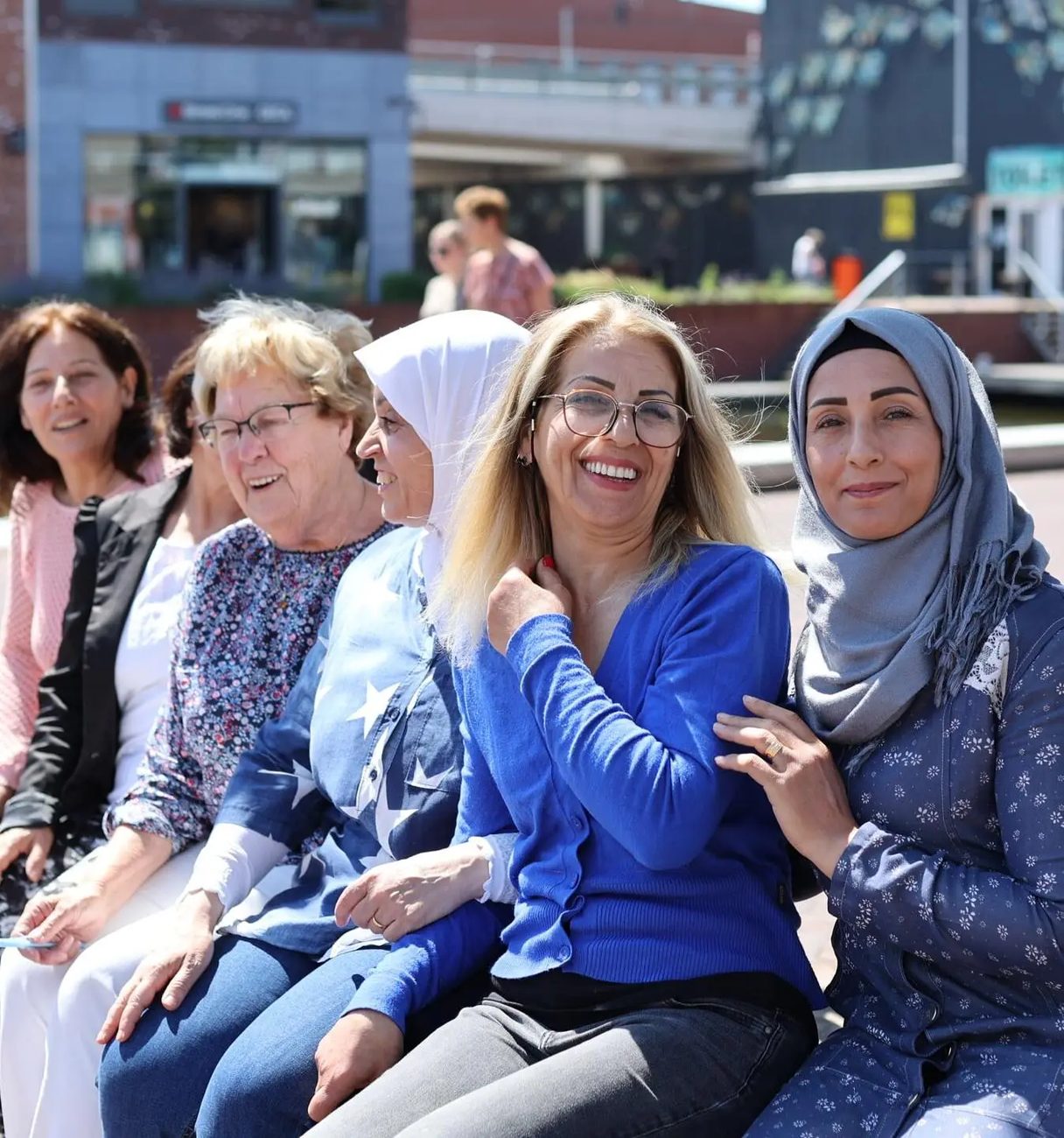 Een groep vrouwen die door SVWA begeleid zijn, samen lachend in het centrum van Almelo